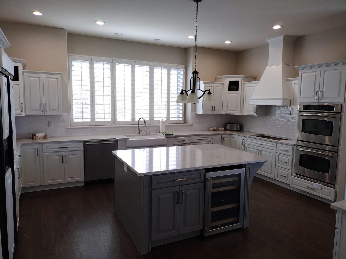 Refinished white upper cabinets and gray island by Rock's Finest Finishes