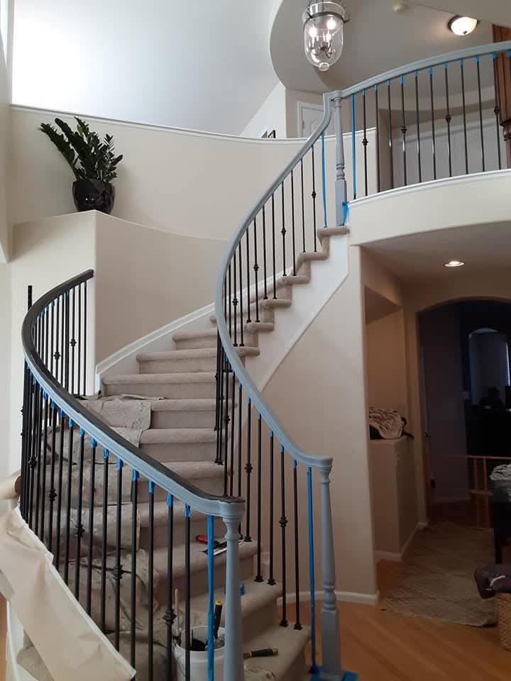 Staircase railing primed gray and taped off mid-job by Rock's Finest Finishes