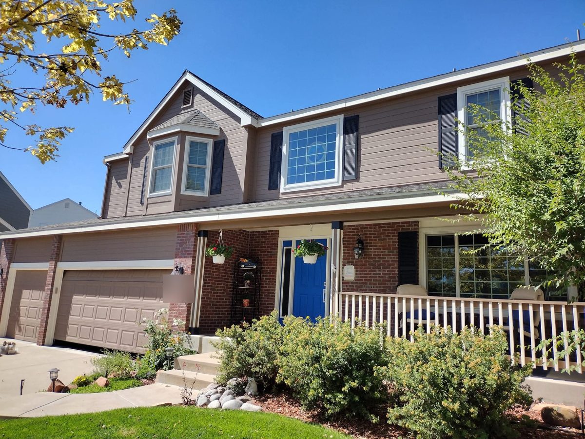 Tan two-story exterior with a blue front door painted by Rock's Finest Finishes