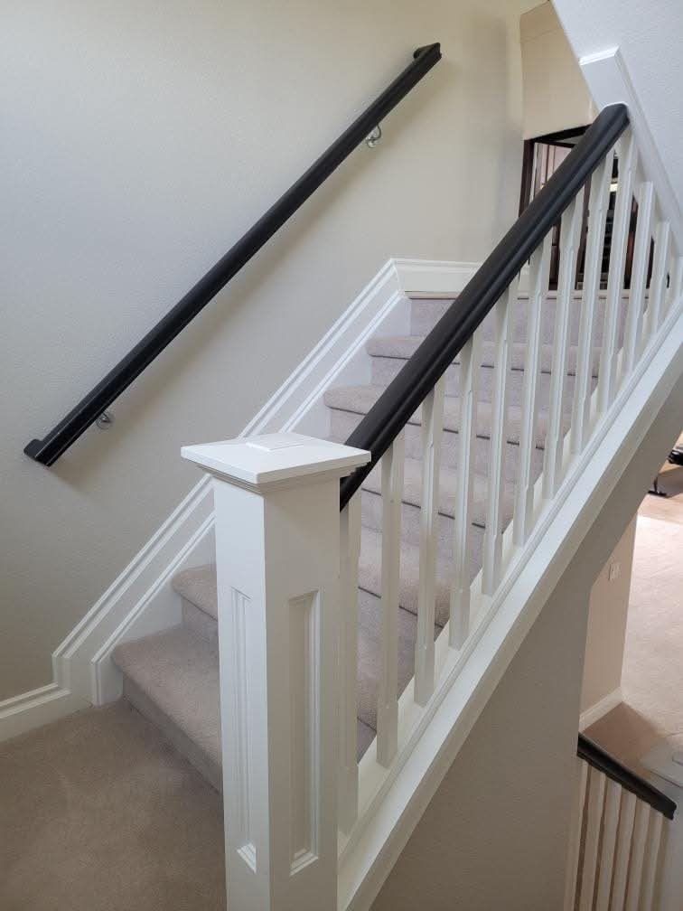 Finished white staircase with dark handrail by Rock's Finest Finishes